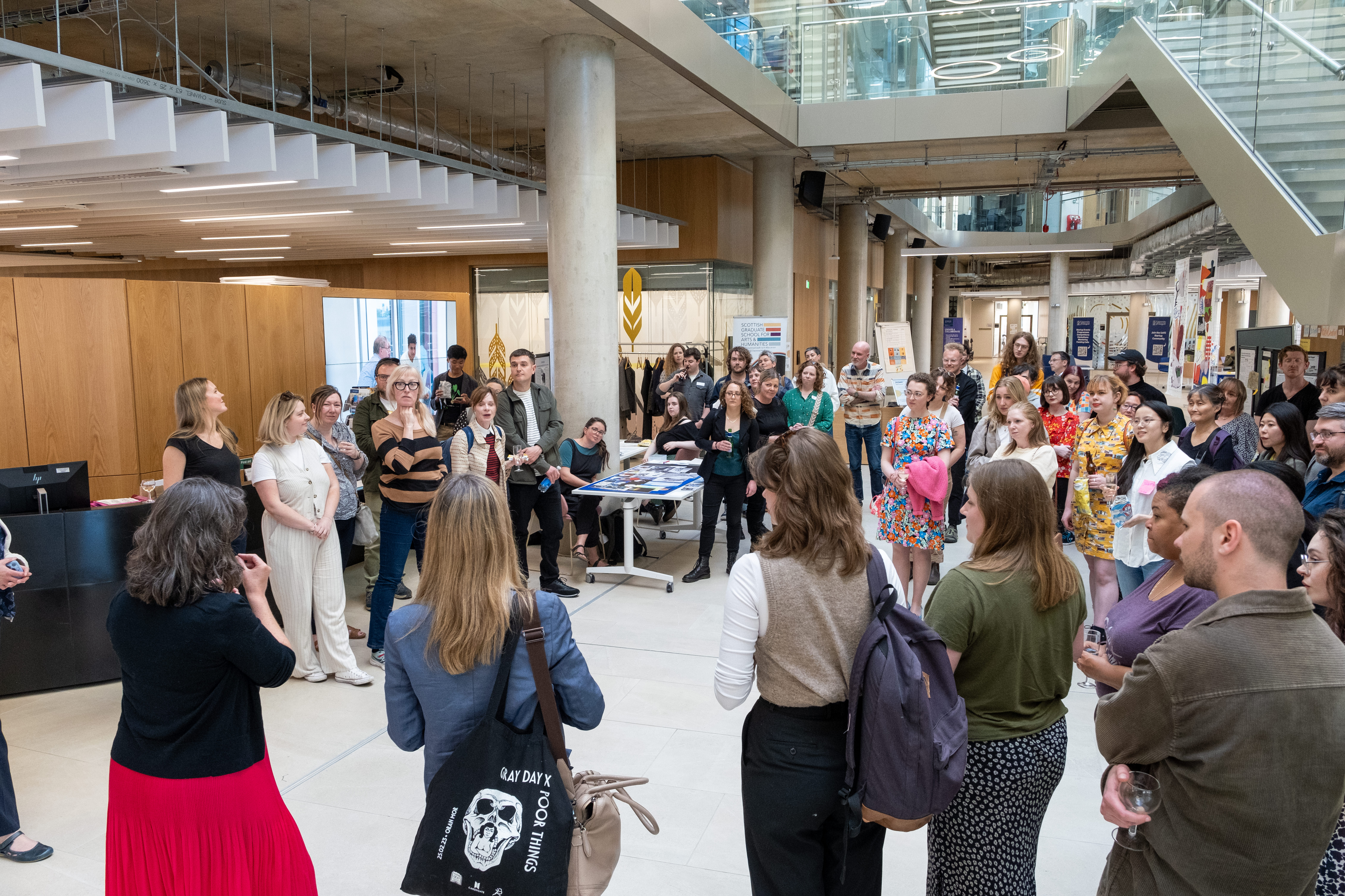 Crowd of people gathered listening to speeches in large atrium