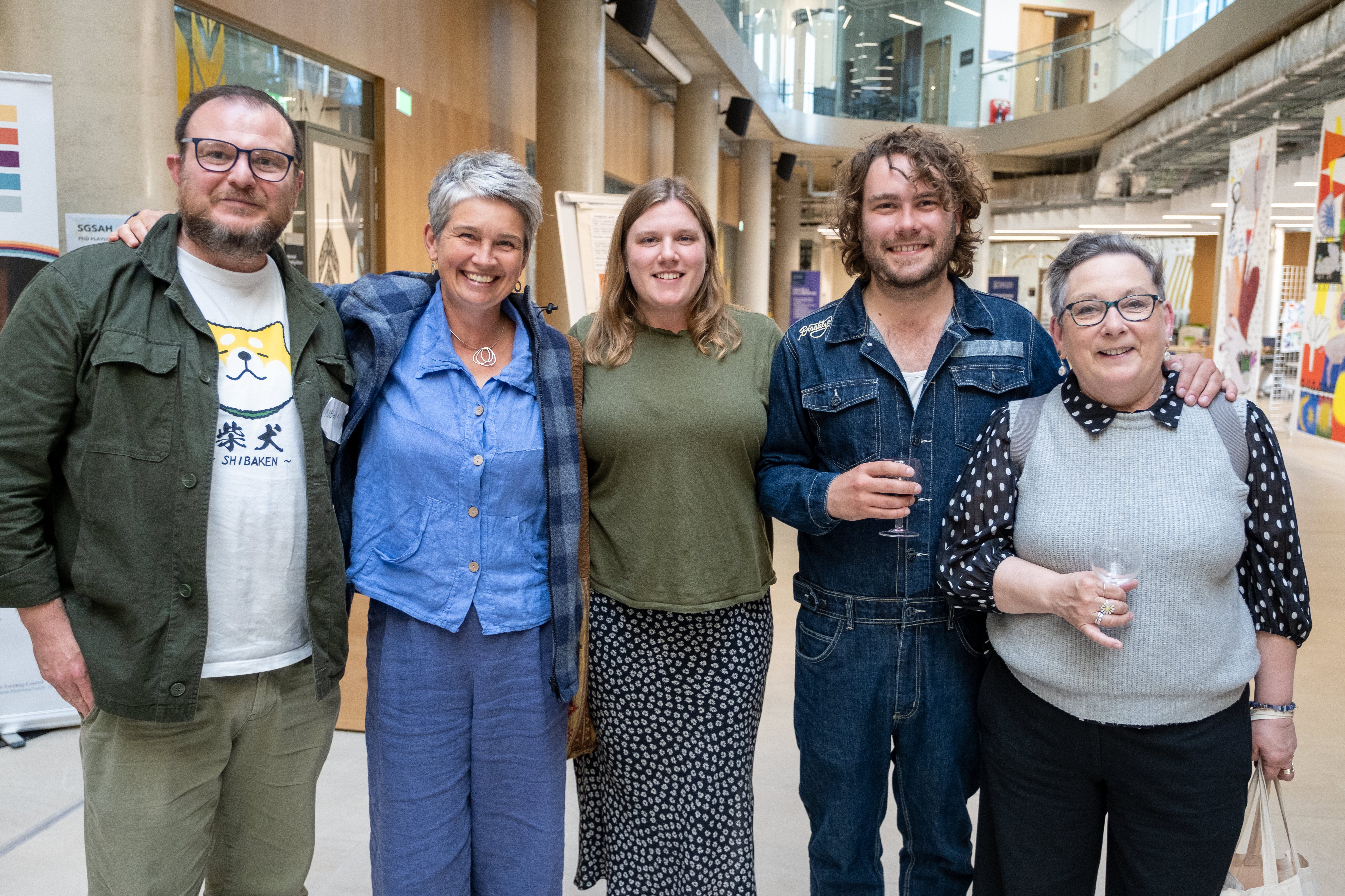 5 students standing smiling in front of research displays
