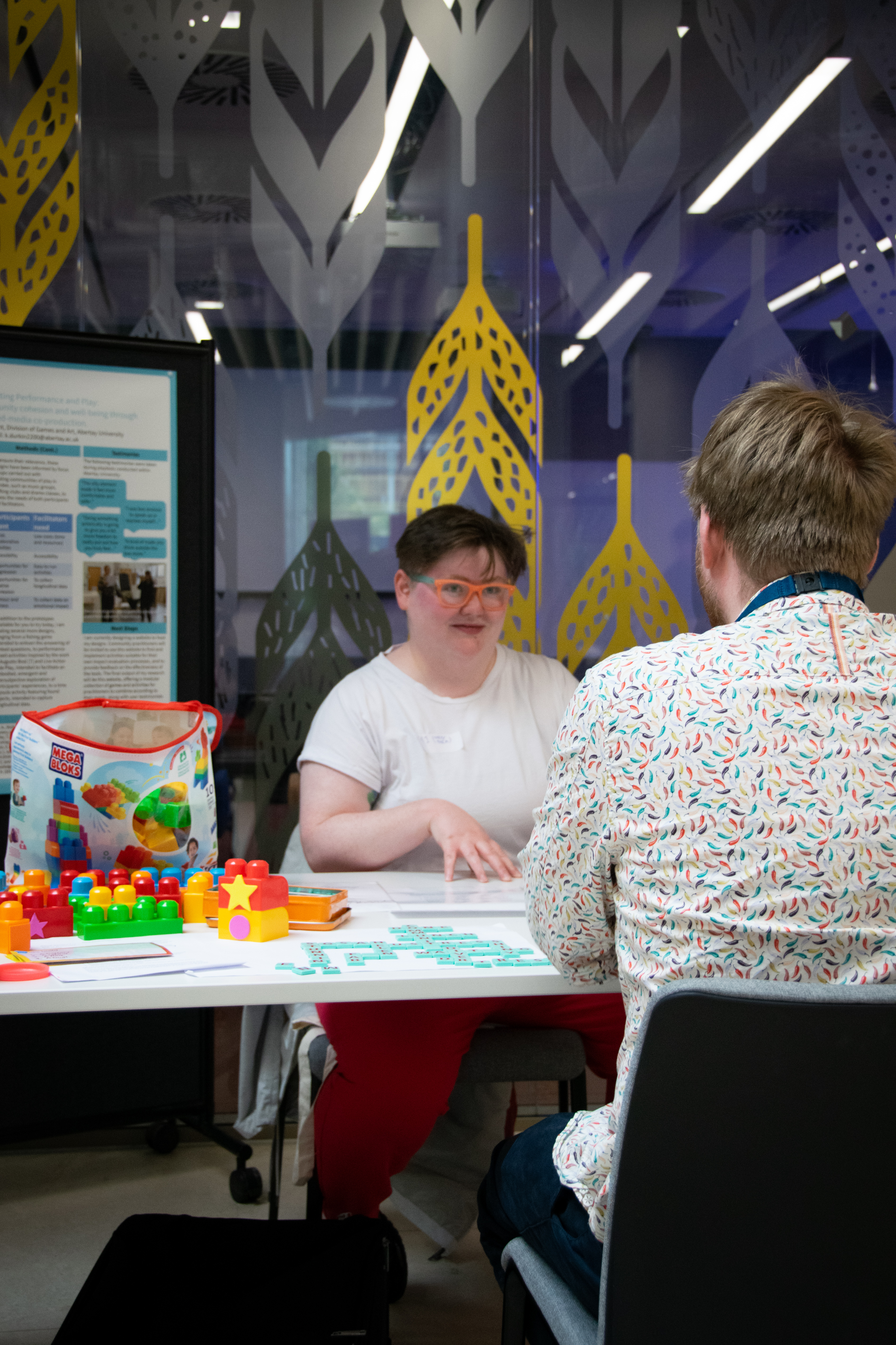 Person with short brown hair exhibiting some information related to their SGSAH Showcase using colourful blocks.