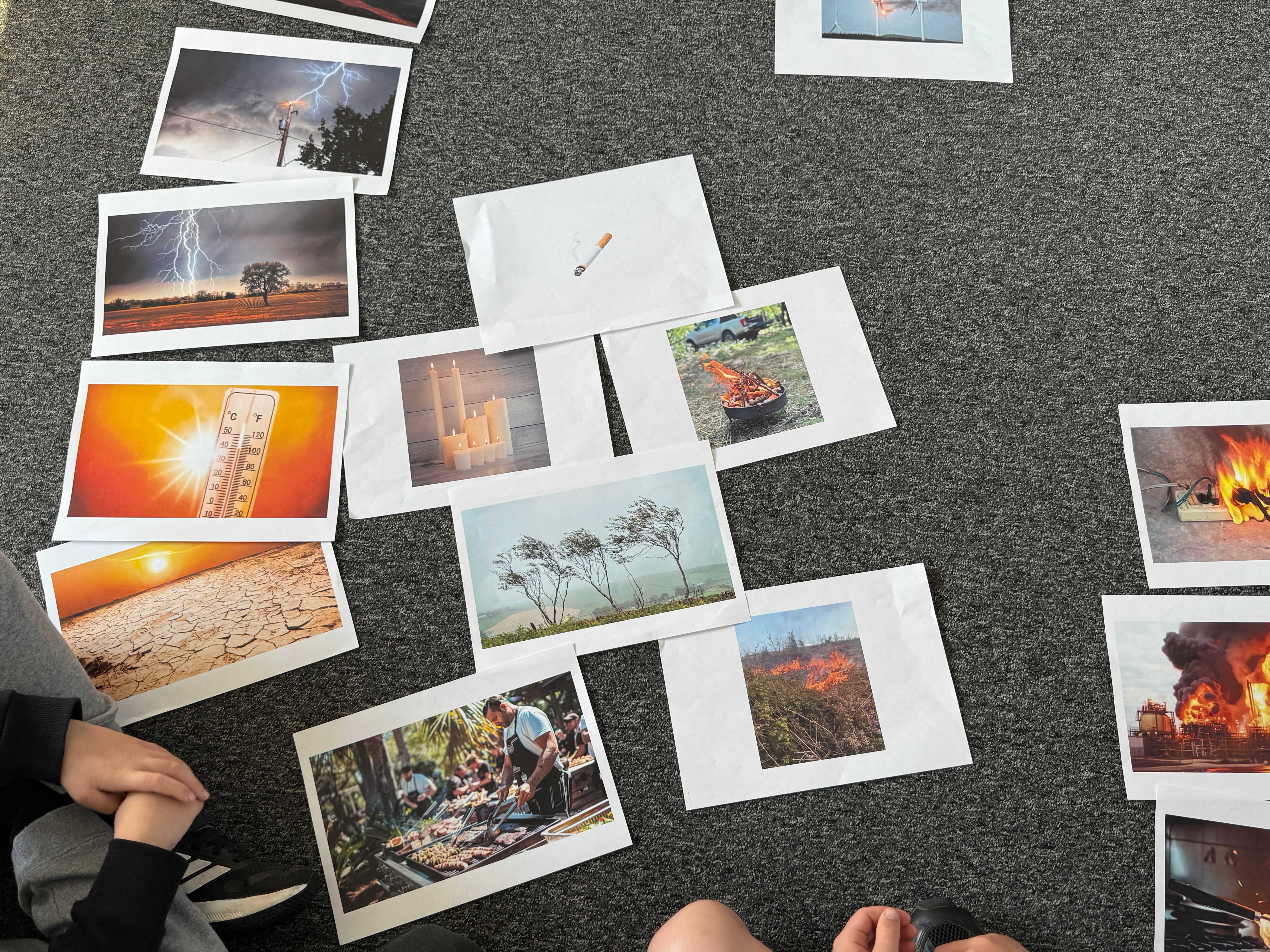 Several climate disaster pictures on the floor. Photo credit: Dr Audrey Cameron.